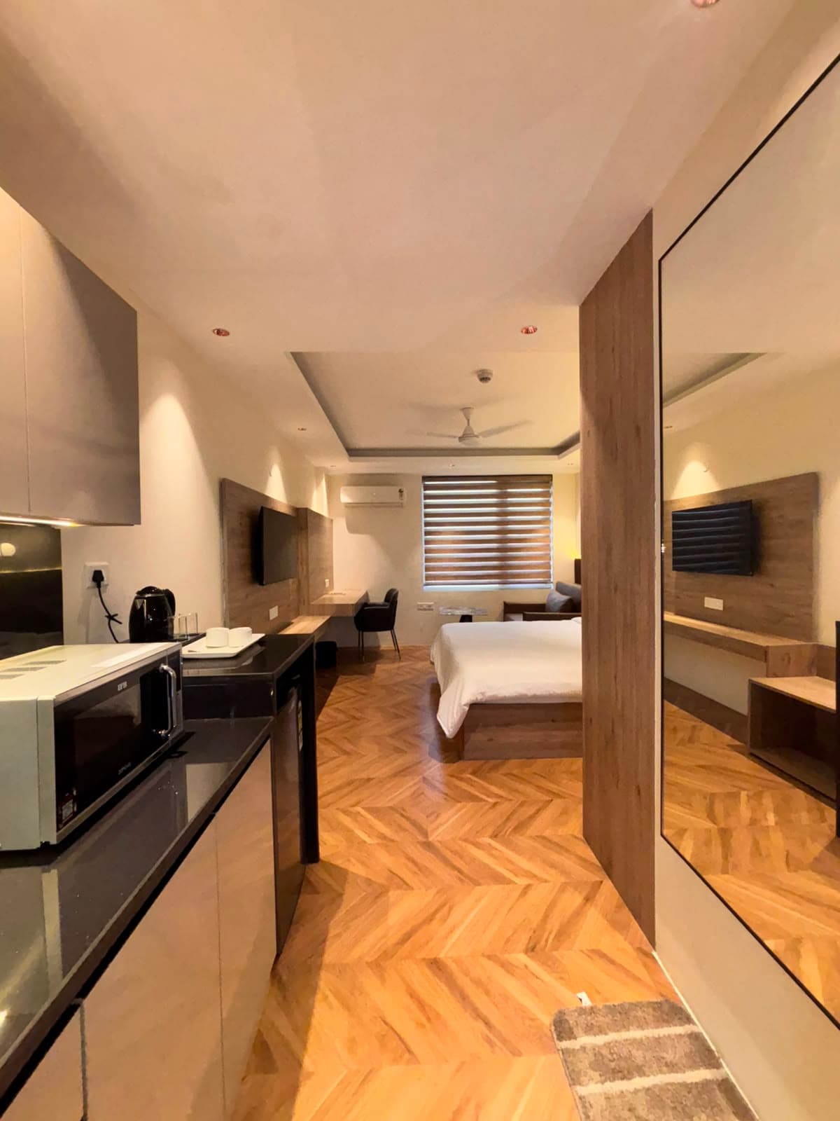 Open-plan studio layout showing the kitchenette, dining counter and bed in Greater Noida