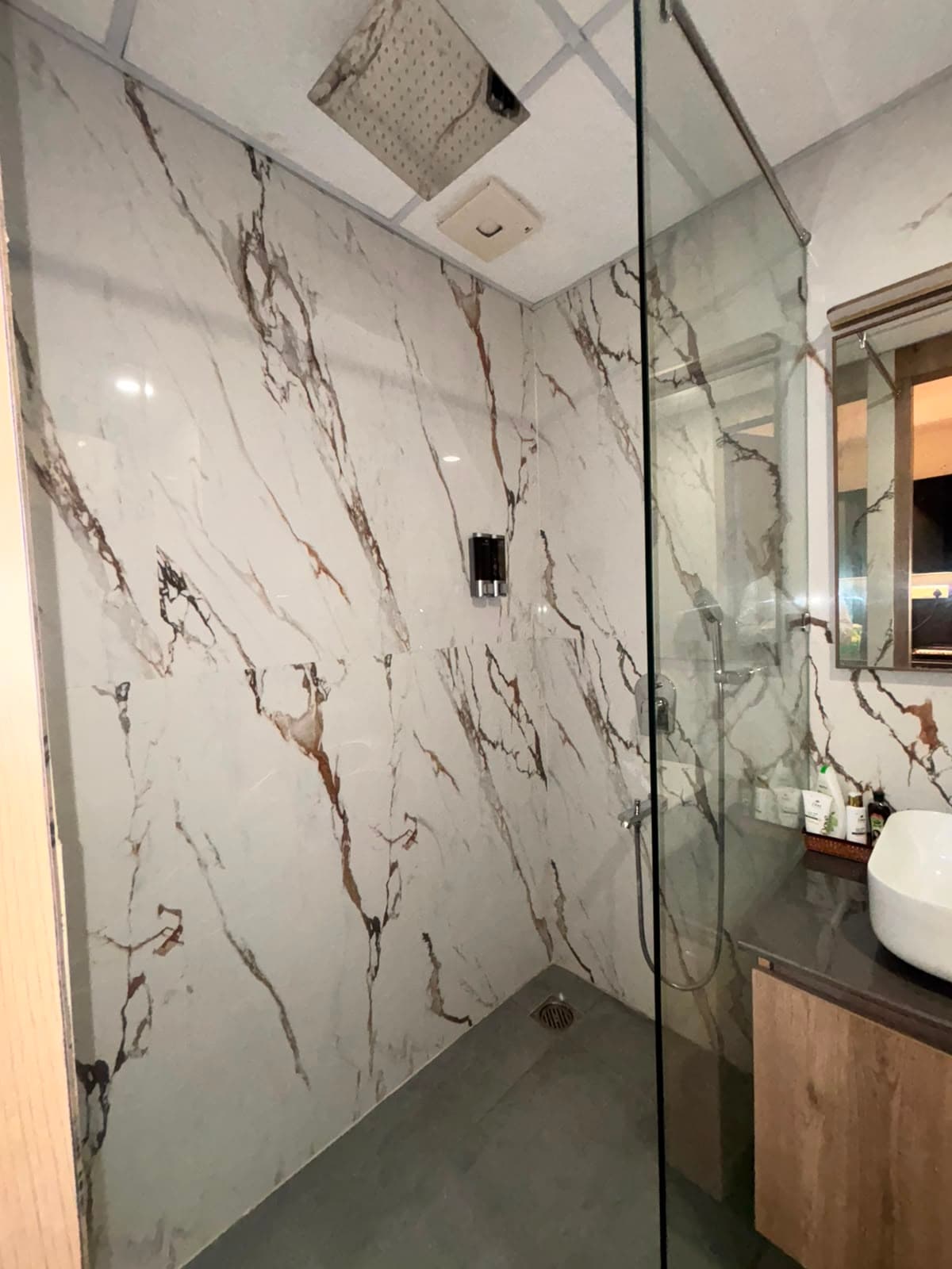 Walk-in rain shower with glass screen and marble tiling